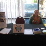 Alyssa Holland smiling at the Wolfner Library exhibitor table