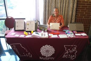 Mary Herder sitting at the exhibitor table