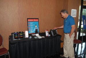 Bruce Becker displaying the Sr. Sidekick device at his exhibit table