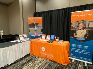 AlphaPointe Exhibit Booth with marketing material and vision simulation goggles displayed on the table